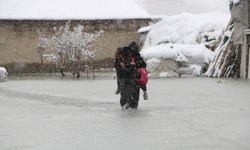 Hakkari'de biriken su nedeniyle çocuklarını sırtında taşıyor