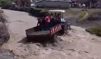 Öğrenciler, debisi yükselen dereyi traktörle geçti