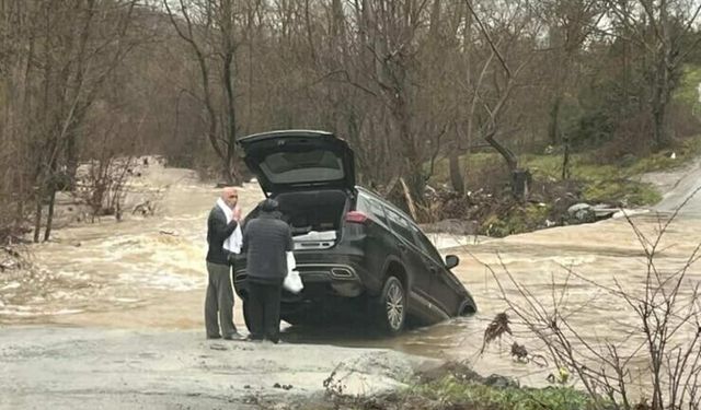 Sağanak nedeniyle köy yolu kapandı, otomobil suya kapıldı