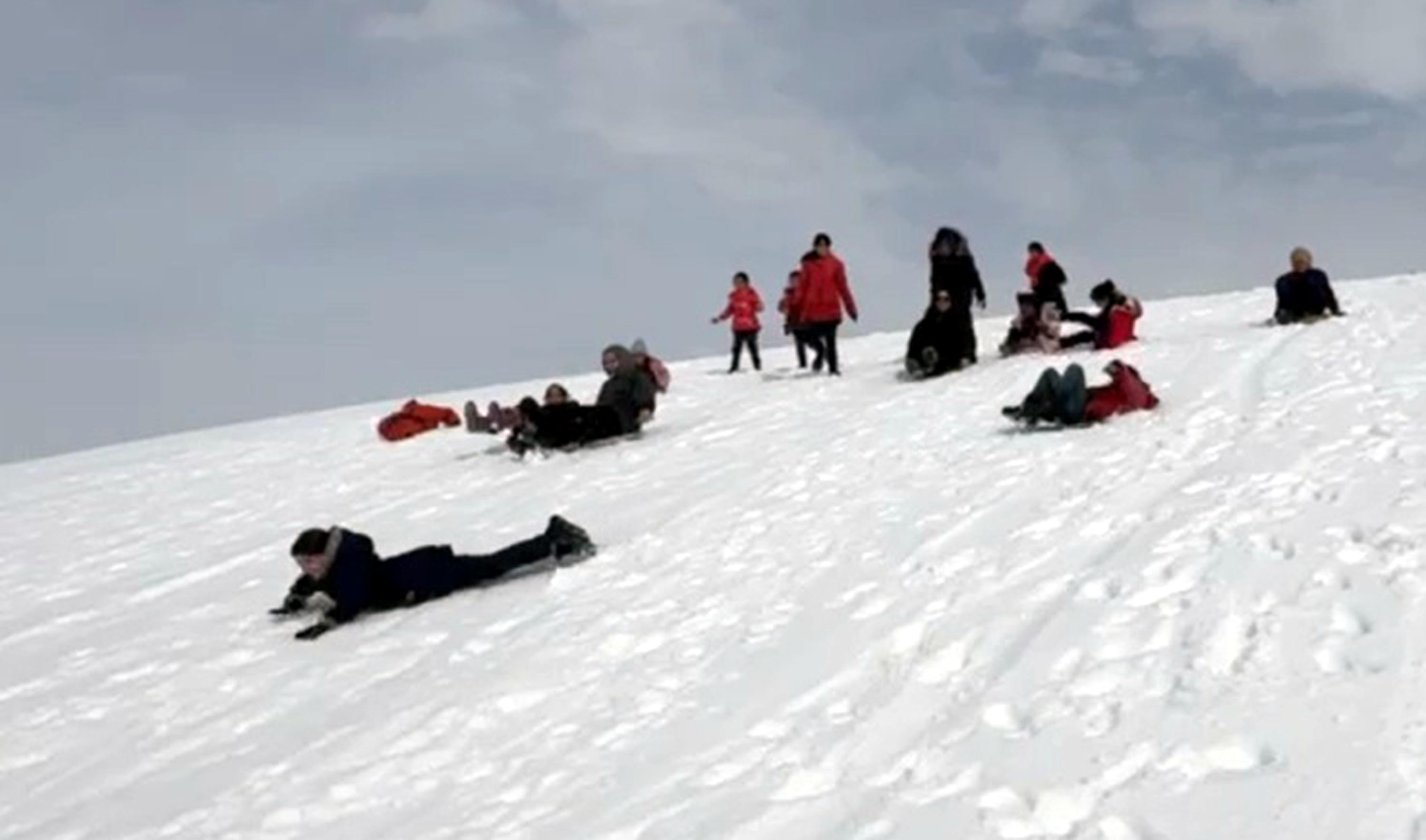 Evlerden getirdikleri tepsilerle köy merasında kaydılar